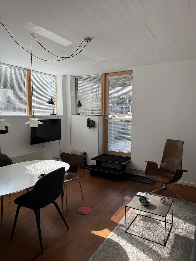 Wohnraum mit Essplatz, Sesseln und Fensterband